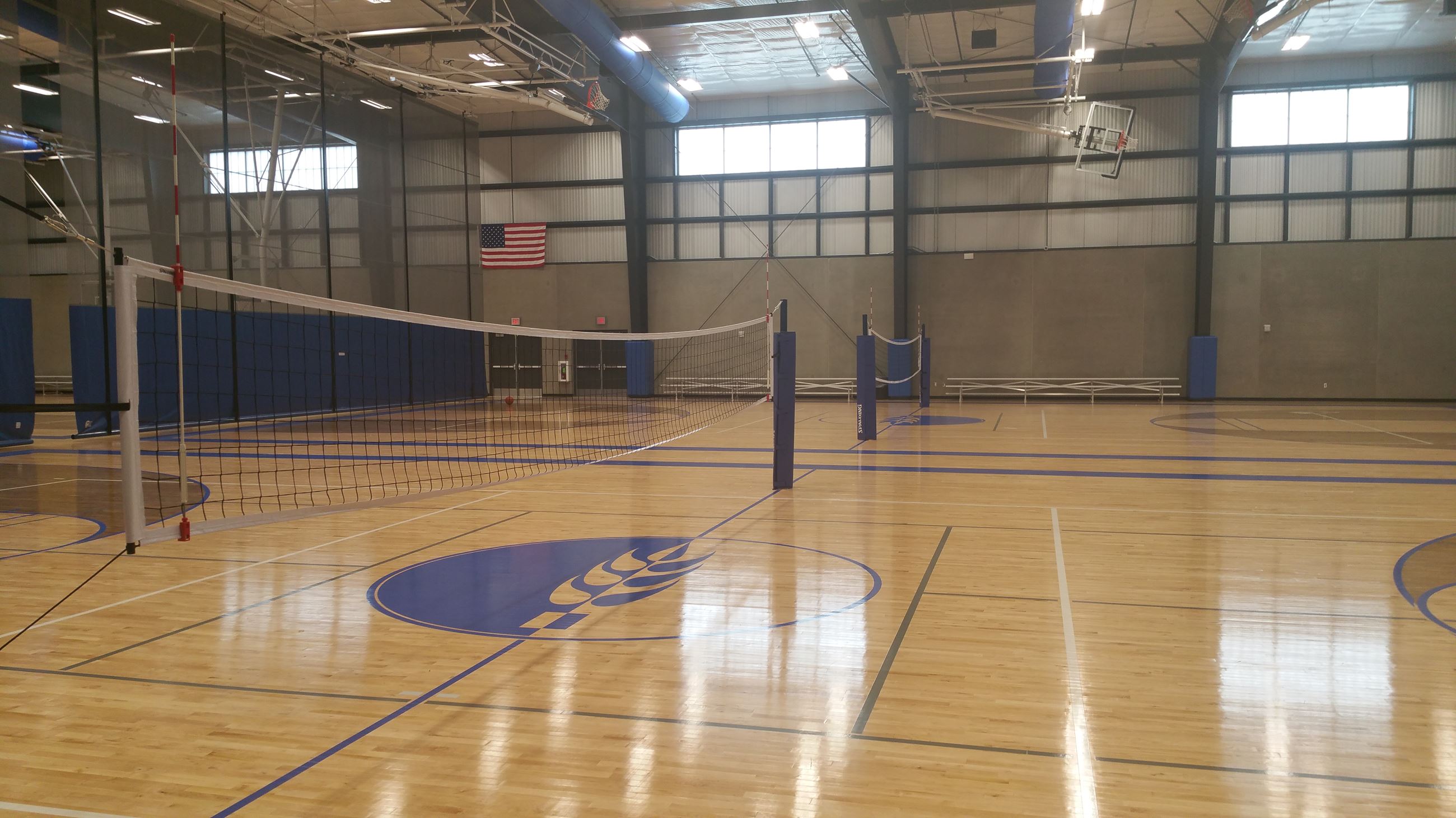 An indoor basketball court set up for a volleyball game